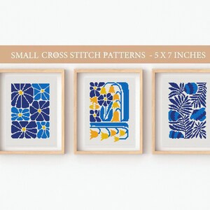 May include: Three framed cross stitch patterns with a blue and yellow floral theme. Each pattern is 5 inches by 7 inches.