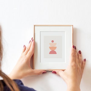 May include: A framed print of a geometric abstract design in shades of red, orange, and beige. The design is made up of stacked circles.