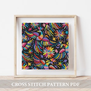 May include: A colorful cross stitch pattern featuring a black background with vibrant flowers, birds, and geometric shapes. The pattern is framed in a light wood frame.