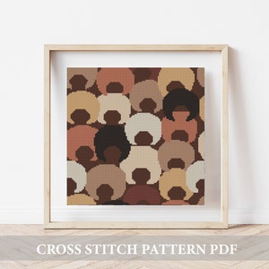 Peut inclure: Un motif de point de croix représentant un design abstrait coloré de cercles qui se chevauchent dans des tons de brun, beige et rose. Le motif est encadré dans un cadre en bois clair et affiché sur un mur blanc.