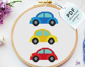 Può includere: Un modello di punto croce con tre auto colorate in un cerchio. Le auto sono blu, gialla e rossa. Il modello è accompagnato da filo da ricamo in colori coordinati e un'etichetta che recita "Modello di download PDF".