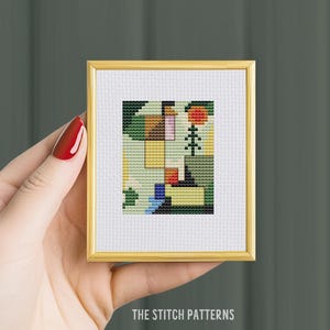 May include: A framed cross-stitch pattern of a geometric abstract painting with a yellow, green, red, blue, and orange colour scheme.