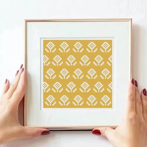 May include: A framed print of a geometric pattern with white flowers on a yellow background.