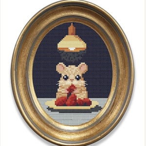 May include: A framed cross-stitch artwork depicting a hamster sitting on a plate with red strawberries and a yellow light fixture above.