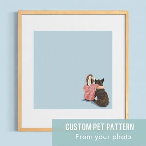 Puede incluir: Arte de punto de cruz enmarcado que presenta a una persona con una camisa rosa con un perro. El fondo es un patrón de cuadrícula azul claro. El texto en la parte inferior dice "CUSTOM PET PATTERN From your photo."