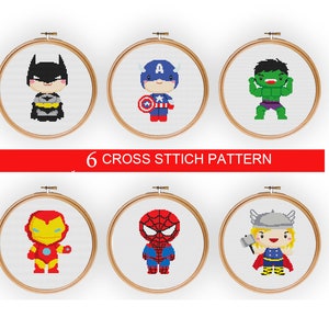 May include: Six cross stitch patterns featuring popular superhero characters. The patterns include Batman, Captain America, Hulk, Iron Man, Spiderman, and Thor. Each pattern is displayed in a circular wooden embroidery hoop.