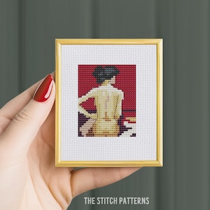 May include: Cross stitch pattern of a woman with short black hair, sitting with her back to the viewer, against a red background.