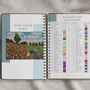 Pode incluir: Caderno aberto em espiral com uma tabela de cores e um rastreador de linha para ponto cruz. A tabela tem n&uacute;meros e nomes de cores DMC com as cores de linha correspondentes. A capa apresenta um padr&atilde;o de ponto cruz de um campo de flores vermelhas.