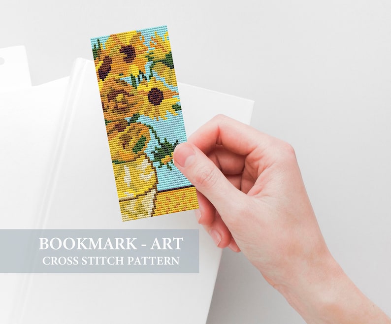 May include: A cross stitch bookmark pattern featuring a vase of sunflowers. The pattern is in shades of yellow, orange, green, and blue.