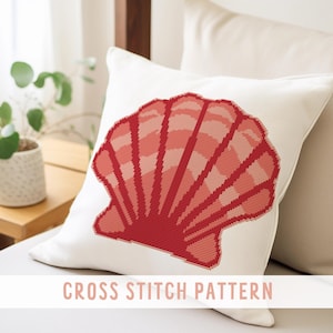 May include: A white cushion featuring a cross-stitch design of a red seashell. The seashell pattern uses different shades of red. The words "CROSS STITCH PATTERN" are at the bottom of the image.