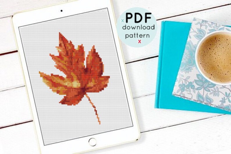 May include: A digital download pattern for cross-stitch featuring a single orange and yellow leaf. The pattern is displayed on a tablet computer.