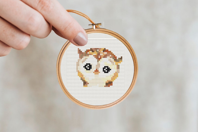 May include: A brown and yellow owl cross-stitch pattern in a wooden embroidery hoop.