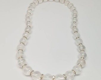 Pode incluir: Um bracelete de contas de cristal branco com detalhes prateados.