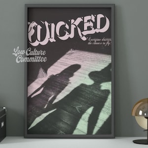 May include: Framed poster with the word "WICKED" in a stylized font. The image features shadows of two figures on a wooden floor, with the text "Everyone deserves the chance to fly." The Low Culture Committee logo is in the lower left corner.