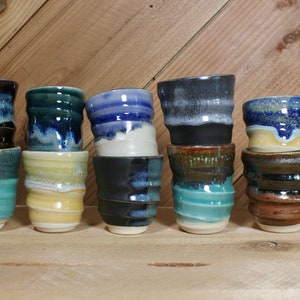 Stack of ceramic shot glasses in multiple colors