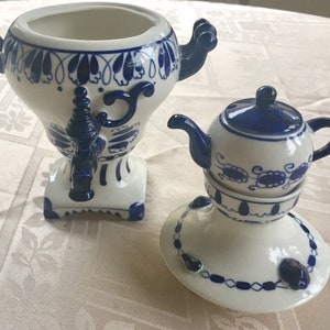 Puede incluir: Un juego de té de cerámica blanca con diseños florales azules y blancos. El juego incluye una tetera y un samovar.