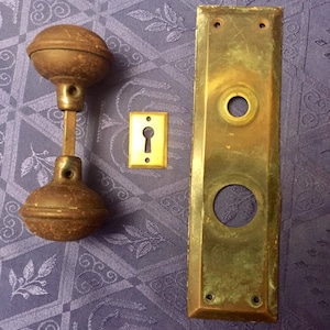 Puede incluir: Un juego de herrajes de puerta de latón antiguo, que incluye un pomo de puerta con dos pomos redondos, una tapa de mirilla y una placa de puerta con dos agujeros para tornillos.