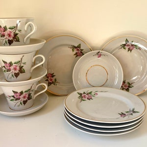 May include: A set of vintage floral teacups and saucers with a delicate pink and green floral pattern. The set includes three teacups, three saucers, and four plates.