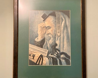 May include: A framed painting of a man wearing a prayer shawl and a kippah, reading a book. The painting is in a dark wood frame with a green mat.