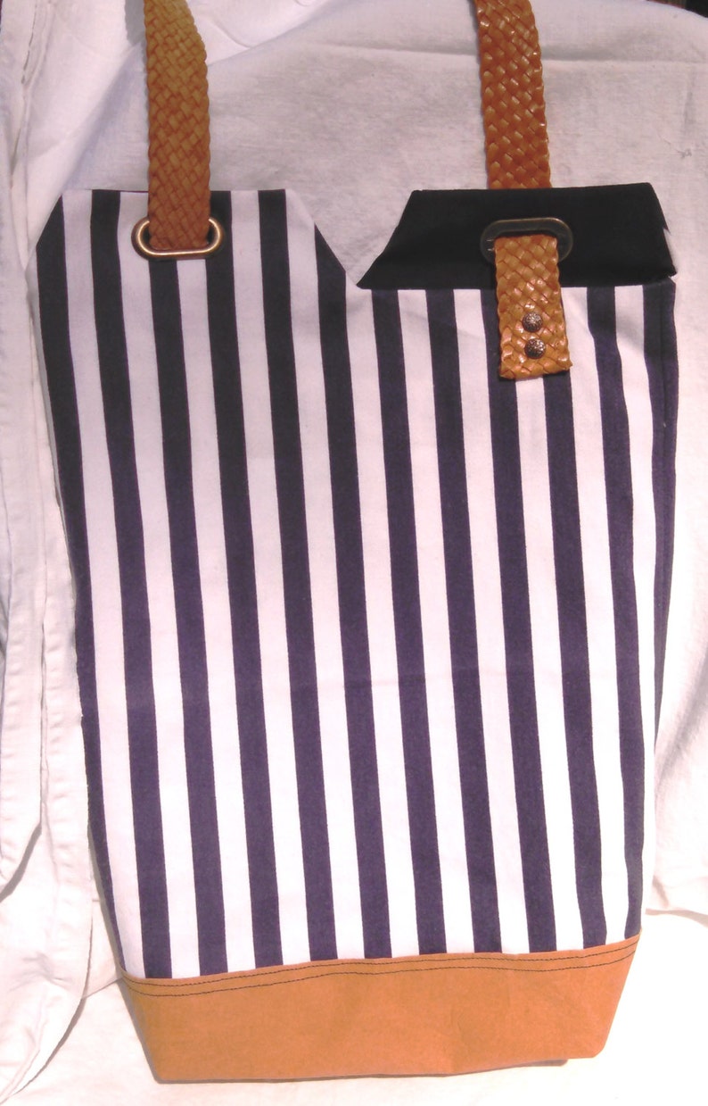 So sharp in navy and white stripes This totepurse has one leather strap that is unique and holds the flaps closed when purse is held.