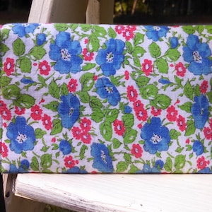 This updated and larger cell phone wristlet is irresistible in this vintage floral fabric. Lined with upcycled denim. Leather wrist strap.