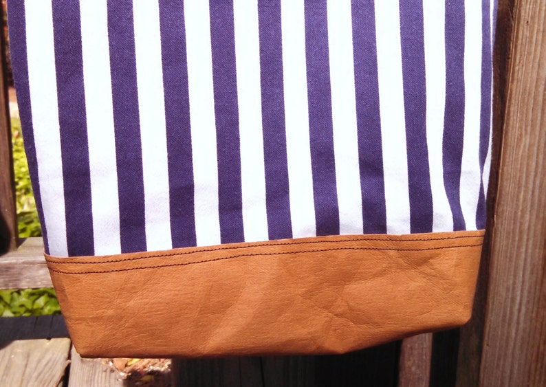 So sharp in navy and white stripes This totepurse has one leather strap that is unique and holds the flaps closed when purse is held.