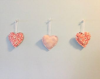 Decorative vintage fabric hearts filled with cotton batting and rose petals.