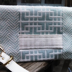 Ivory hand strap makes carrying this mint and ivory convertible clutch a breeze. If you need free hands, attach the removable shoulder strap