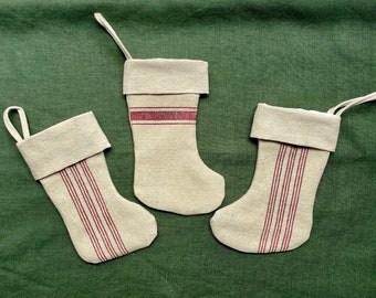 Christmas stockings created from rustic natural linen with red stripes, top cuff, fully lined, and each has a hanging loop