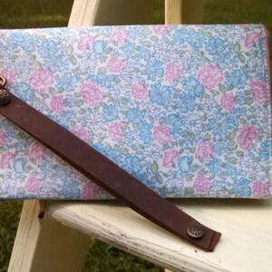 This larger updated cell phone wristlet in a pastel pink, blue, green, yellow floral print will hold your phone, cards, and other items.