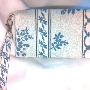 This smartphone wristlet will fit  phones measuring up to 5.75&quot;x3.5&quot;.  An additional inner pocket will hold all your cards. Blue and white