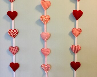 Mini fabric hearts vertical wall hanging in shades of red, pink, white.