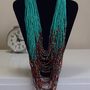 Puede incluir: Un collar largo de cuentas turquesa y multicolores. El collar est&aacute; hecho de cuentas peque&ntilde;as y est&aacute; en capas para crear un efecto en cascada.