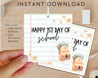 May include: A printable "Happy 1st Day of School" tag featuring a backpack graphic, stars, and a lined paper design. The tag is held by a hand and includes the text "Instant Download" and "Two Files".