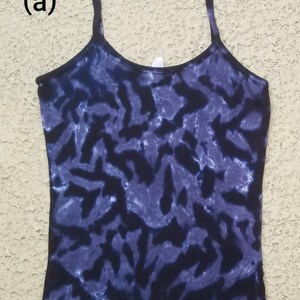 May include: A black and blue tie-dye tank top with a scalloped hem. The tank top is labeled "XL (a)".