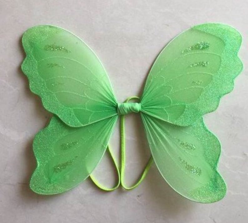 K&ouml;nnte beinhalten: Gr&uuml;ne Schmetterlingsfl&uuml;gel mit Glitzer, aus durchsichtigem Stoff und mit einem Gummiband befestigt.