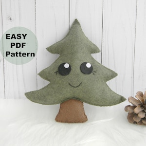 Op de afbeelding: Een groene kerstboom van vilt met een bruine viltstam en een glimlachend gezicht met zwarte ogen. De boom staat op een witte achtergrond met de tekst "EASY PDF Pattern" in een cirkel.