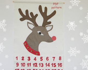 May include: A white felt reindeer head with a red nose and a red and gold collar. The reindeer head is on a white background with the numbers 1 through 24 printed below. The text "PDF pattern" is printed at the top of the image.