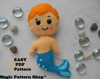 May include: A felt toy mermaid with orange hair, a blue tail with sequins, and a smiling face. The toy is on a white background with small glass beads and stones.