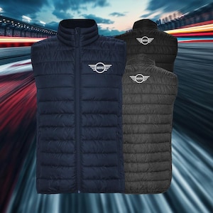 May include: Three quilted vests in navy blue, black, and charcoal gray. Each vest features a stand-up collar, a full-length zipper, and the "MINI" logo in white on the chest and upper back. The vests are displayed against a blurred background.