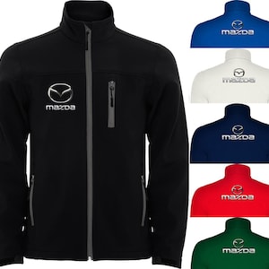 Op de afbeelding: Zwarte softshell jas met een volledige ritssluiting, opstaande kraag en borstzak. Het Mazda-logo is wit op de borst geborduurd. Extra jassen in blauw, wit, marine, rood en groen.