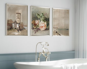 May include: Three framed prints in a bathroom setting. The prints are in silver frames and feature a cityscape, a floral still life, and a seascape.