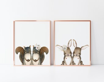 May include: Two sets of framed prints featuring watercolor illustrations of animal couples. The first print shows two squirrels holding hands, while the second print shows two bunnies holding hands.
