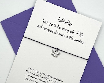 May include: A white card with a black string attached to a silver butterfly charm. The card reads "Butterflies lead you to the sunny side of life and everyone deserves a little sunshine. Close your eyes and make a wish then put this bracelet on your wrist when your bracelet breaks in two your wish is ready to come true. Individually Handmade by Looks Inviting www.looksinviting.co.uk"