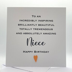 Puede incluir: Una tarjeta blanca con texto negro que dice "To an incredibly inspiring brilliantly beautiful totally tremendous and absolutely amazing Niece Happy Birthday". Un peque&ntilde;o coraz&oacute;n naranja est&aacute; en el centro inferior de la tarjeta.