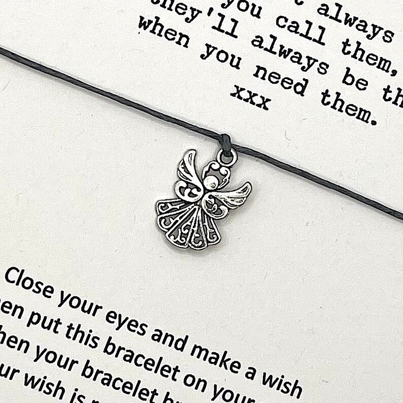 May include: A black string bracelet with a silver angel charm. The bracelet comes with a card that reads "Close your eyes and make a wish then put this bracelet on your wrist. When your bracelet breaks, your wish is coming true. They'll always be there when you need them. XXX"