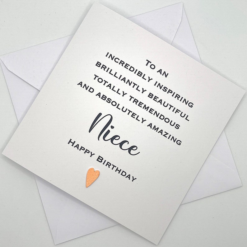 Puede incluir: Una tarjeta blanca con texto negro que dice "To an incredibly inspiring brilliantly beautiful totally tremendous and absolutely amazing Niece Happy Birthday" con un peque&ntilde;o coraz&oacute;n dorado.