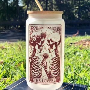 Vaso de vidrio esmerilado con tapa de bambú y pajita con la carta del Tarot de los Enamorados