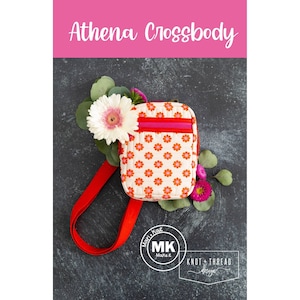 May include: A red and white crossbody bag with a floral print and a pink zipper. The bag is on a dark gray background with flowers.