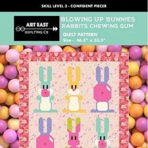 May include: A quilt pattern featuring six cartoon bunnies with different coloured fur and clothing. The pattern is called "Blowing Up Bunnies Rabbits Chewing Gum" and is 103 cm x 136 cm.